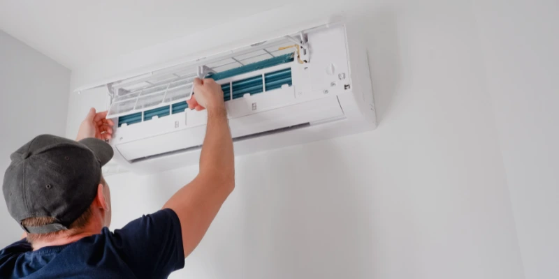 Técnico realizando mantenimiento de aire acondicionado en un edificio, asegurando su eficiencia energética y prolongando su vida útil. Mantenimiento de aire acondicionado