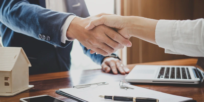 Representación de un acuerdo profesional para la administración de un condominio en Costa Rica, con apretón de manos entre cliente y administrador.