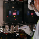 Técnico de Mabinsa realizando inspección de tablero eléctrico en edificio comercial en Costa Rica. Electromecánica preventiva: cómo evitar fallas eléctricas en edificios comerciales.