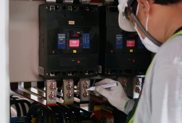 Técnico de Mabinsa realizando inspección de tablero eléctrico en edificio comercial en Costa Rica. Electromecánica preventiva: cómo evitar fallas eléctricas en edificios comerciales.