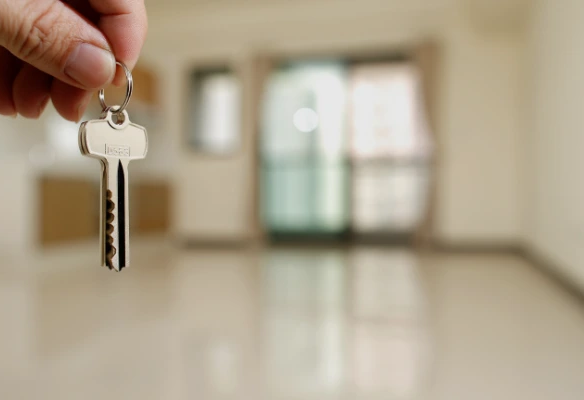 Administrador de propiedad entregando llaves a inquilino feliz en apartamento moderno. Administración de propiedades en alquiler en Costa Rica: tranquilidad para propietarios