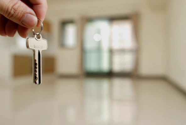 Administrador de propiedad entregando llaves a inquilino feliz en apartamento moderno. Administración de propiedades en alquiler en Costa Rica: tranquilidad para propietarios