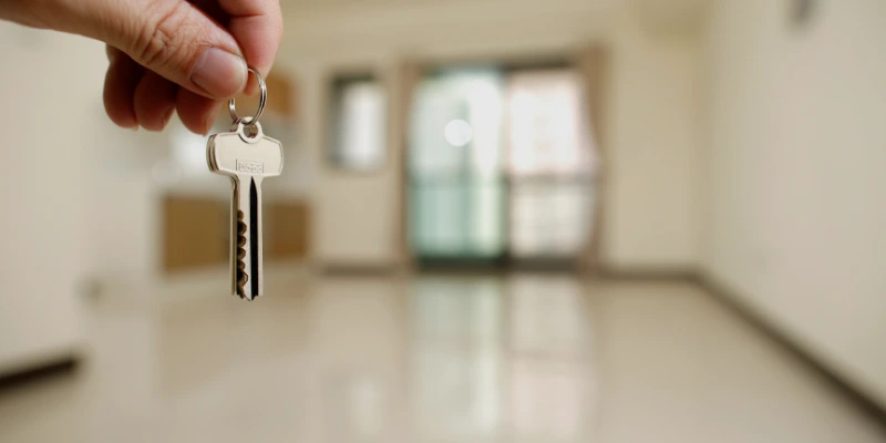 Administrador de propiedad entregando llaves a inquilino feliz en apartamento moderno. Administración de propiedades en alquiler en Costa Rica: tranquilidad para propietarios