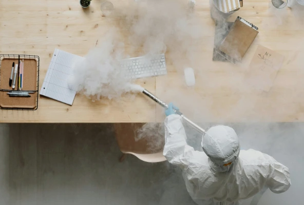Técnico de fumigación de Mabinsa aplicando tratamiento en una oficina moderna en Costa Rica. Fumigación preventiva en oficinas y edificios comerciales en Costa Rica