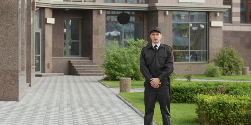 Guardia de seguridad privada saludando en la entrada de un condominio residencial moderno en Costa Rica