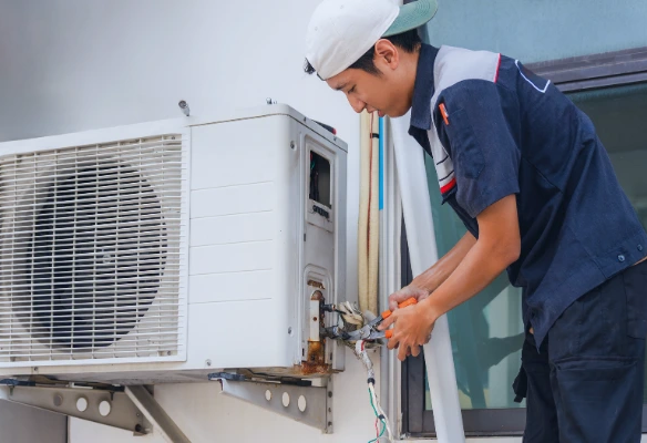 aires acondicionados de bajo consumo. Oficina con aire acondicionado eficiente y técnico revisando configuración para reducir consumo eléctrico en Costa Rica.